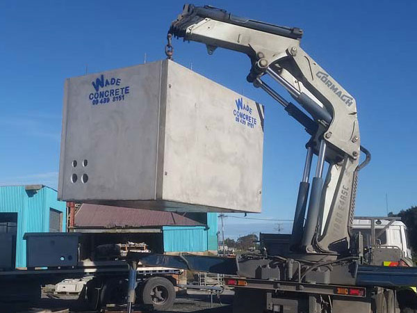 Precast concrete optic fibre tank being lifted into position